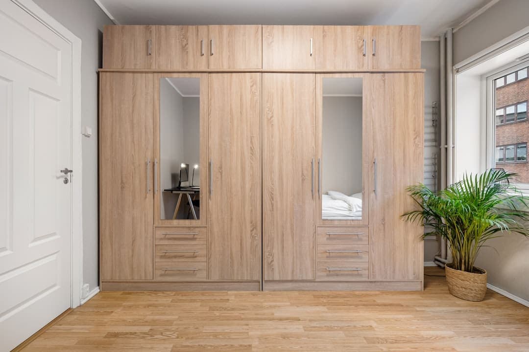 Custom wardrobe with wooden fronts and mirrors in a bedroom