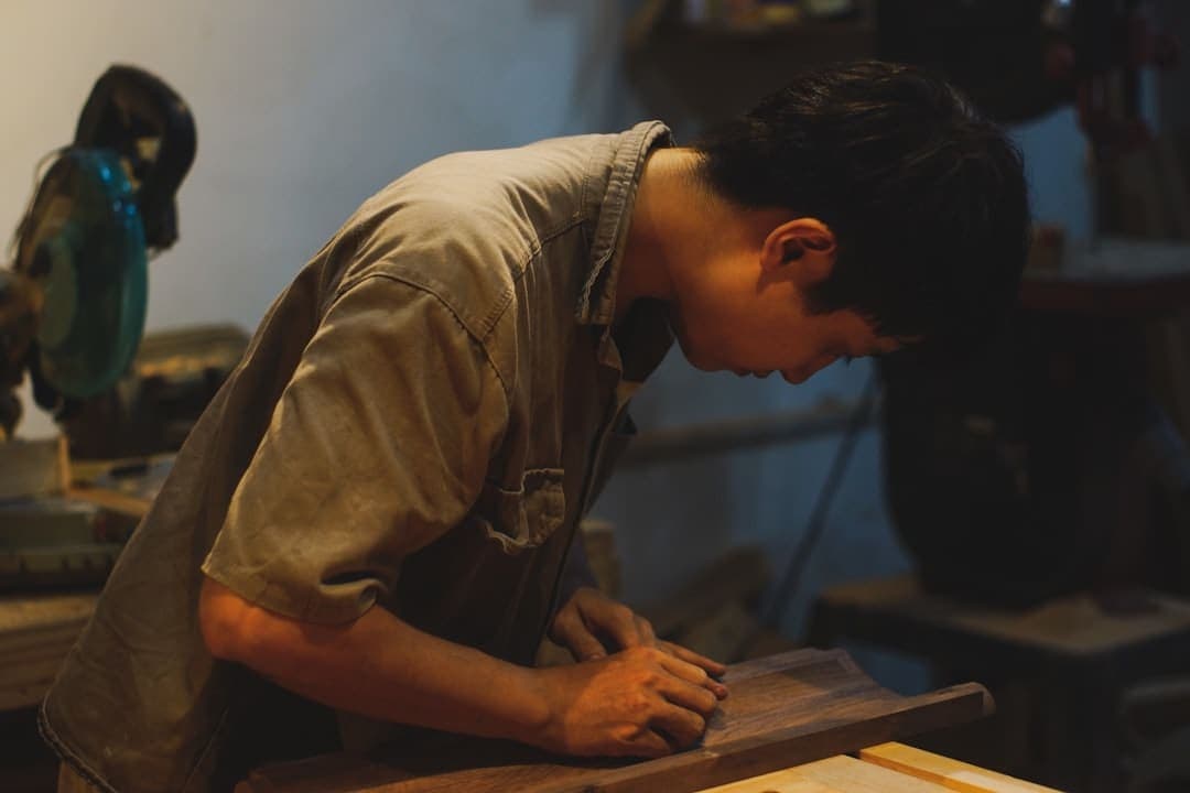 Carpenter sanding a board in the workshop